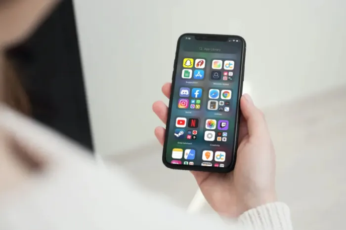 Айфон с приложениями на экране в руке