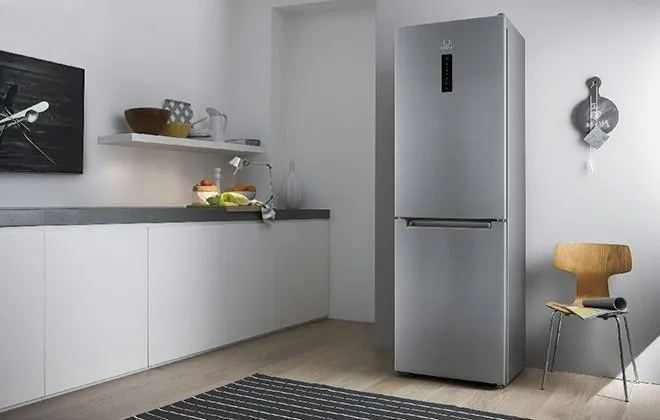 Серебристый отдельностоящий холодильник на кухне