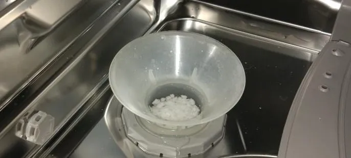 Отверстие с воронкой в посудомоечной машине для засыпания соли от образования накипи