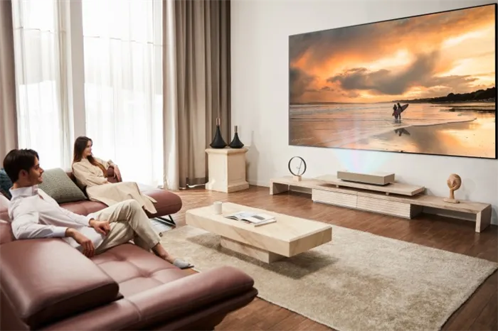 A couple watching an image displayed by the LG CineBeam HU915QE ultra short throw 4K laser projector.