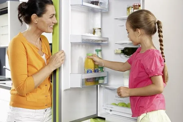 Женщина и ребенок у открытого холодильника